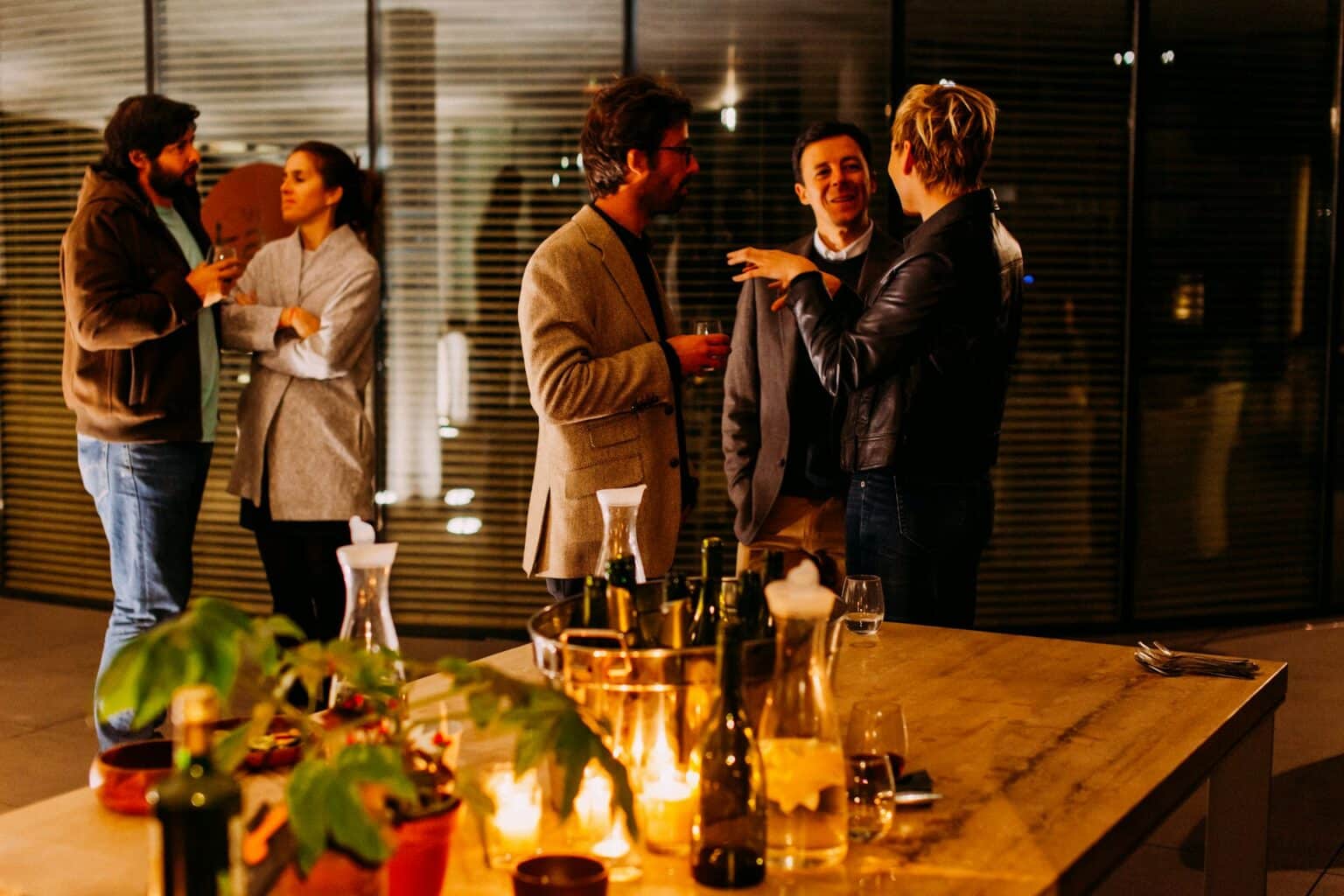 Gäste unterhalten sich bei einem Business-Networking-Event in stilvoller Abendatmosphäre.