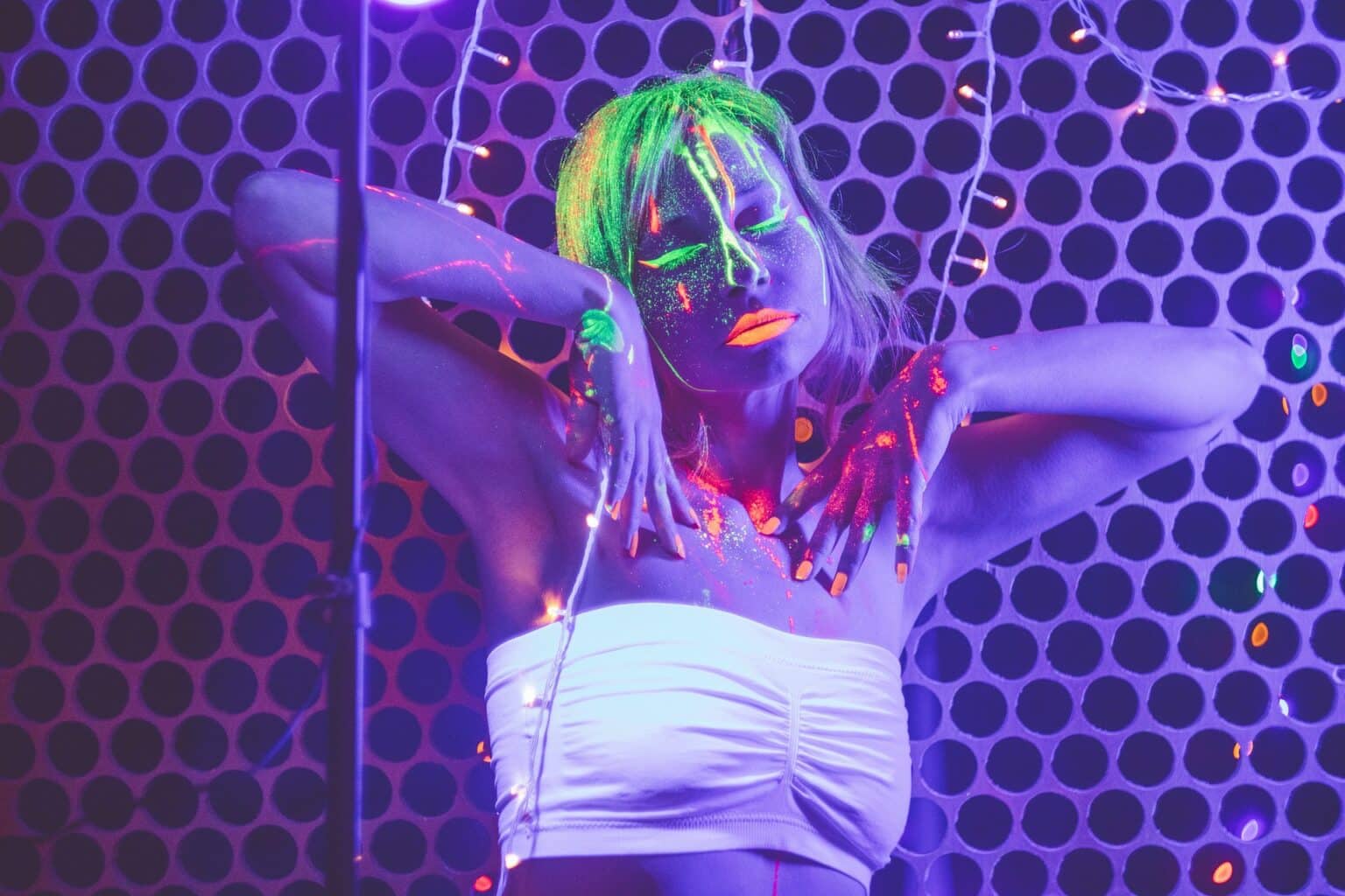 Gast mit fluoreszierendem Neon-Make-up bei einer UV-Party